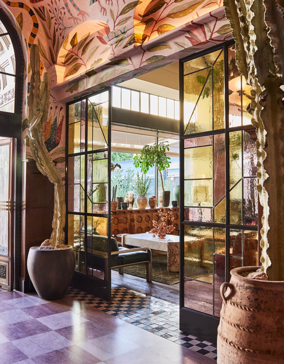 A central America-inspired hotel lobby baths in terracotta tile tones, wooden details, and handmade murals informed by the natural world.