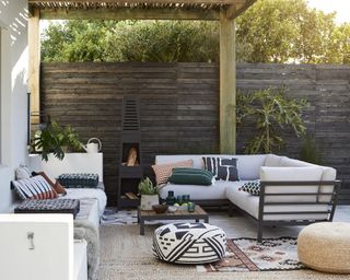 An outdoor patio space with outdoor cushions and printed pouffe