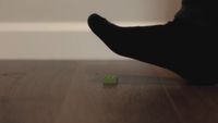 A socked foot, about to step on a LEGO brick