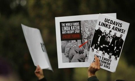 Occupy protesters hold signs during a demonstration at the UC Davis campus