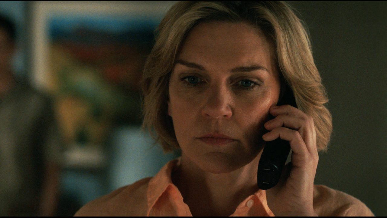 Carol looking stern while listening to a phone call in Pluribus episode 9