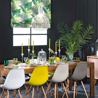 room with wooden table candle stand and black wall