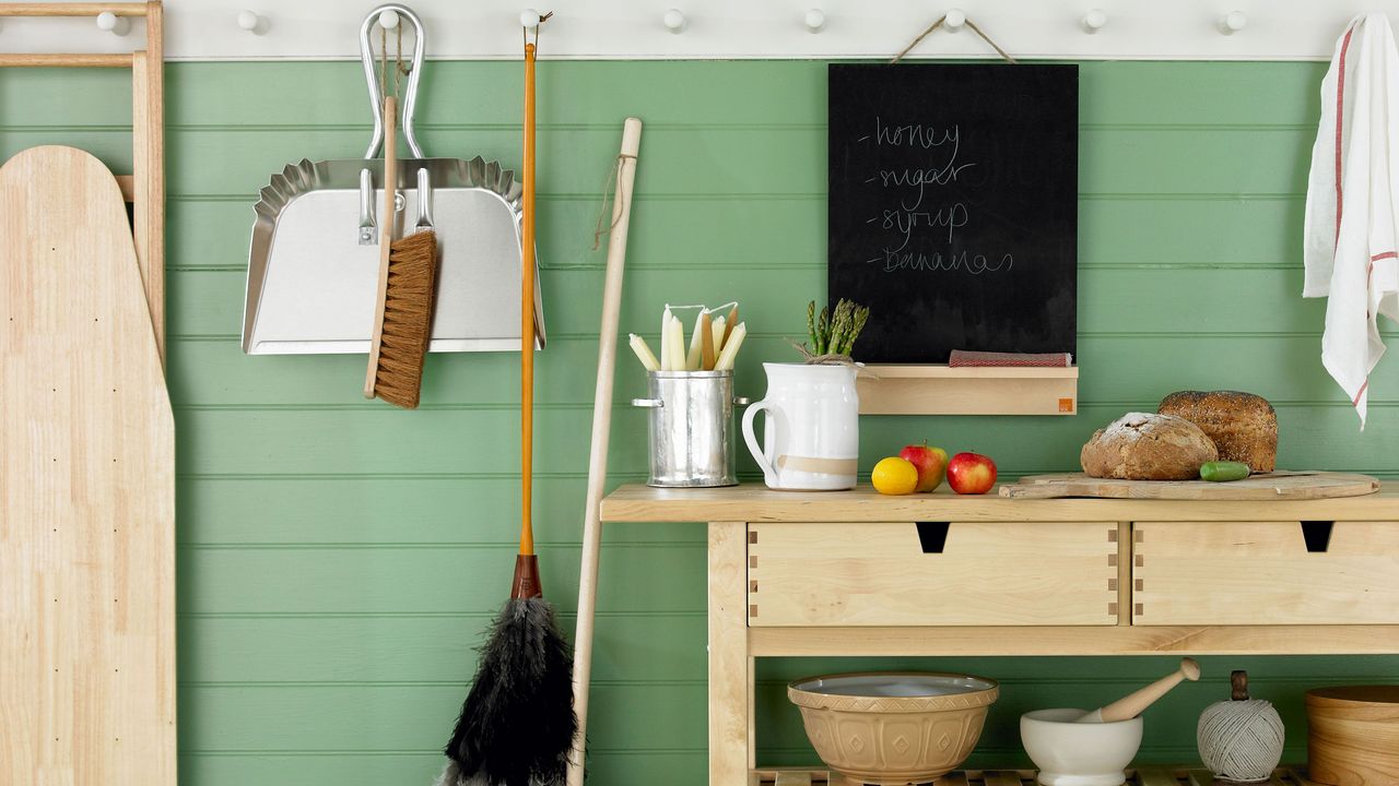 cleaning equipment hanging on pegs and side table with drawers