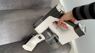 The Tineco Pure One S12 Pro EX being use din handheld mode to clean stairs