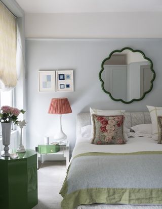 Pretty pale blue bedroom with green mirror