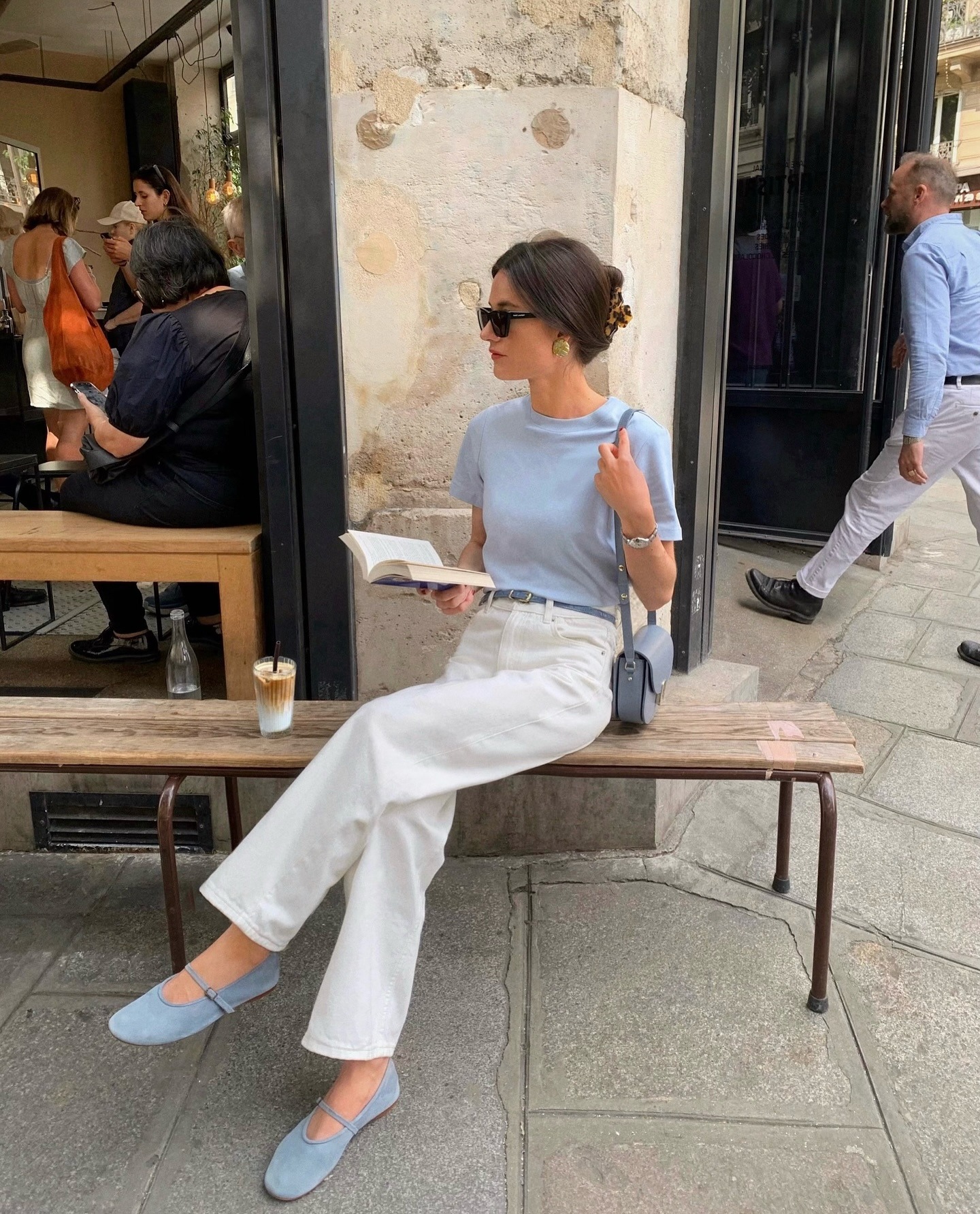Influenciadora francesa usando blusa e sapatos azuis com jeans branco