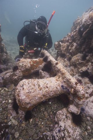 Diver Patrick Smith examines one of two massive mooring bitts discovered at the George E. Billings site. Mooring lines were secured from the mooring bitts to similar bitts on wharfs and docks called bollards.