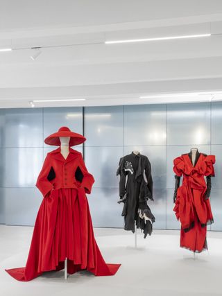 Installation image of Yohji Yamamoto exhibition at 10 Corso Como featuring sculptural black, white and red dresses