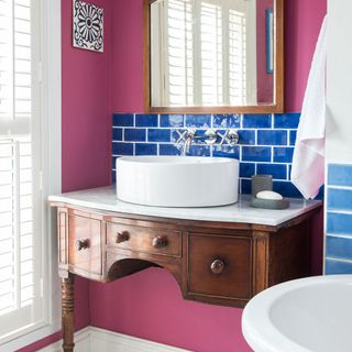 bathroom with pink wall white wash basin and brown drawer