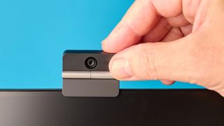 Obsbot Meet Flip foldable webcam photographed in front of a blue background
