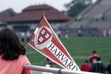 A Harvard flag being waved at a football game