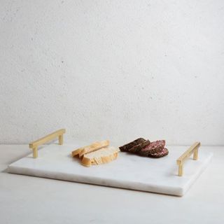 Marble and brass charcuterie board with handles by West Elm