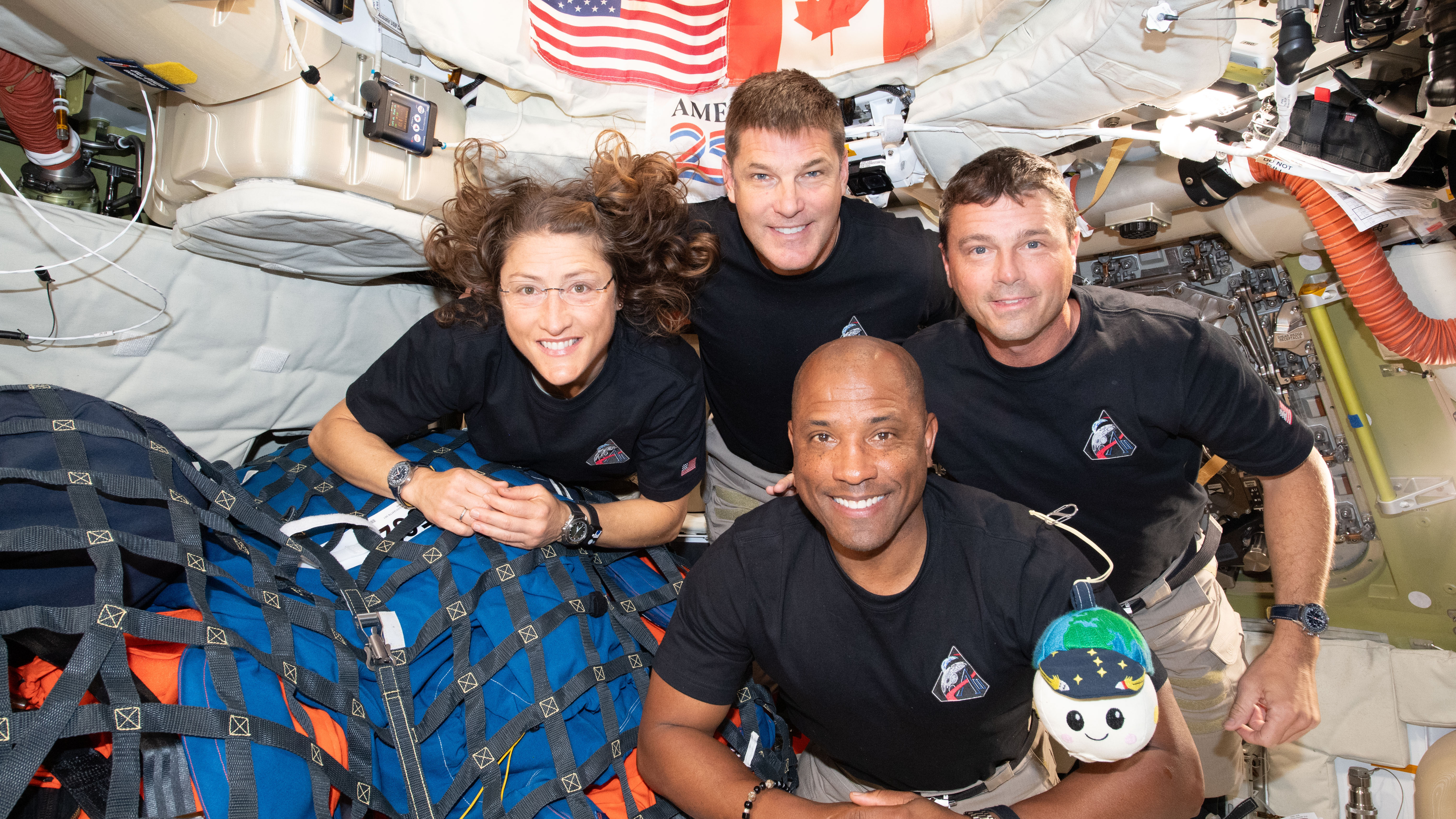 art002e013365 (April 7, 2026) &ndash; The Artemis II crew &ndash; (clockwise from left) Mission Specialist Christina Koch, Mission Specialist Jeremy Hansen, Commander Reid Wiseman, and Pilot Victor Glover &ndash; pause for a group photo with their zero gravity indicator "Rise," inside the Orion spacecraft on their way home. Following a swing around the far side of the Moon on April 6, 2026, the crew exited the lunar sphere of influence (the point at which the Moon's gravity has a stronger pull on Orion than the Earth's) on April 7, and are headed back to Earth for a splashdown in the Pacific Ocean on April 10.