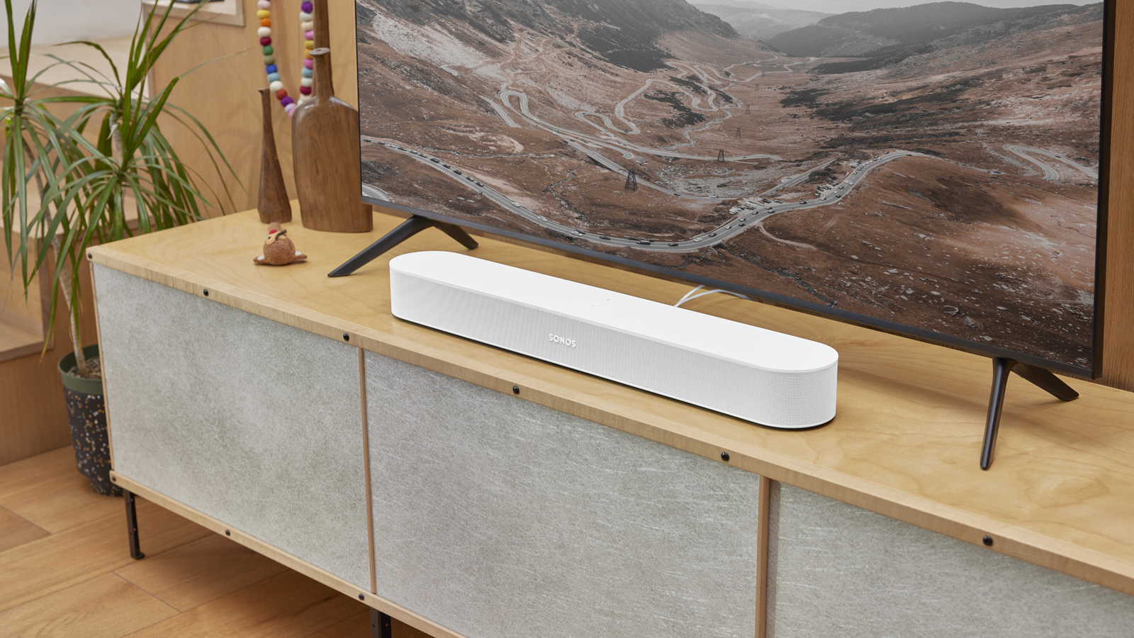 the sonos beam soundbar in white on a TV stand