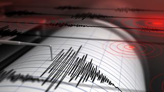 Illustration of how earthquakes are recorded using a seismograph. Oscillating black lines create a series of peaks and troughs on a piece of white paper. 