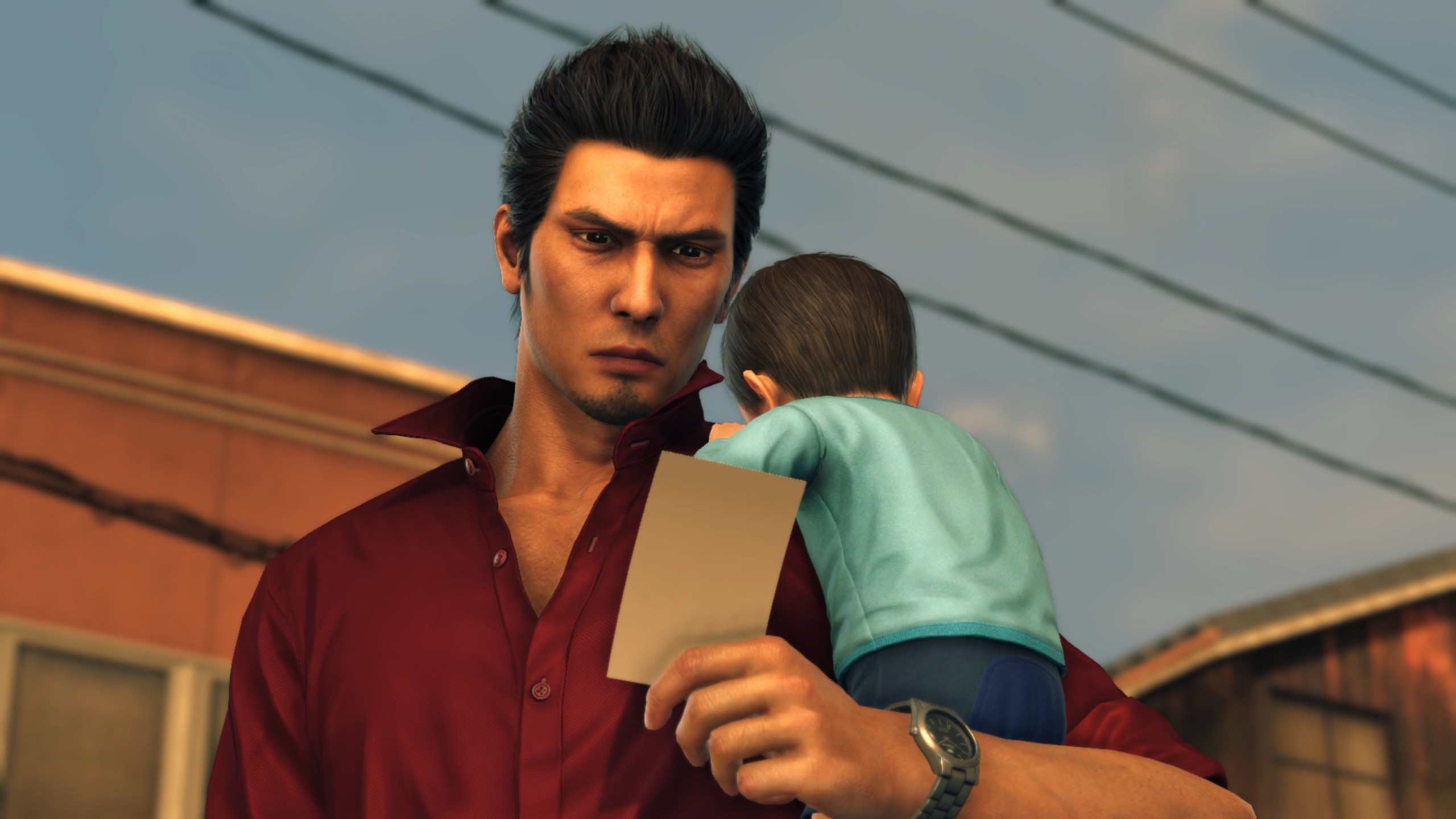 Kiryu looks at a picture, with Haruto cradled on his shoulder.