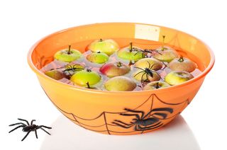 Orange bowl with apples floating in water