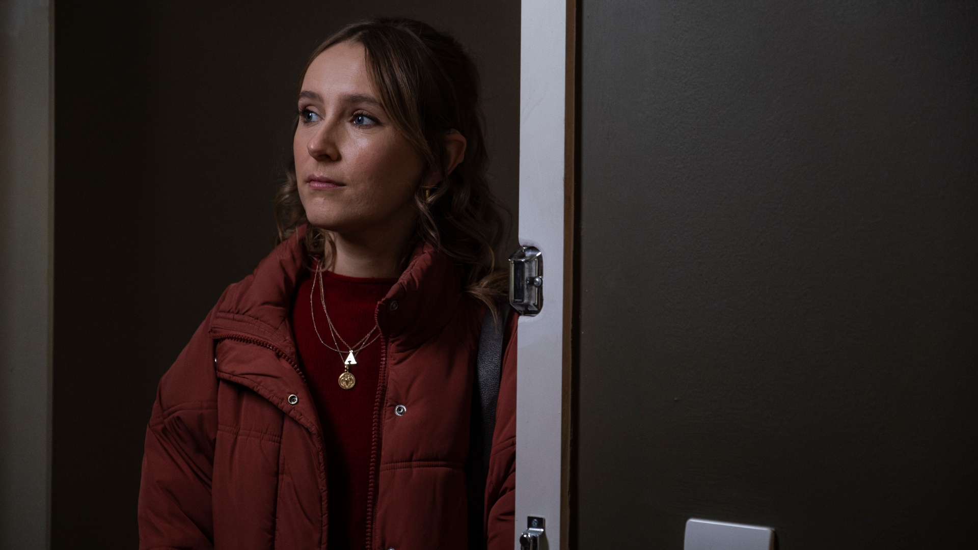 Alison stands at a doorway in Code of Silence