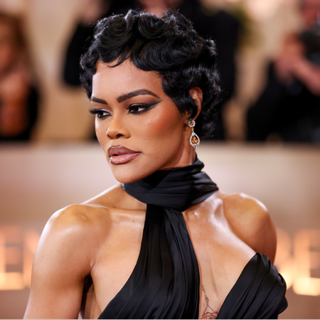 a black woman with short hair poses for a photo at a red carpet event