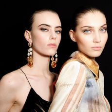 two models wearing smokey eyeshadow backstage at fashion week