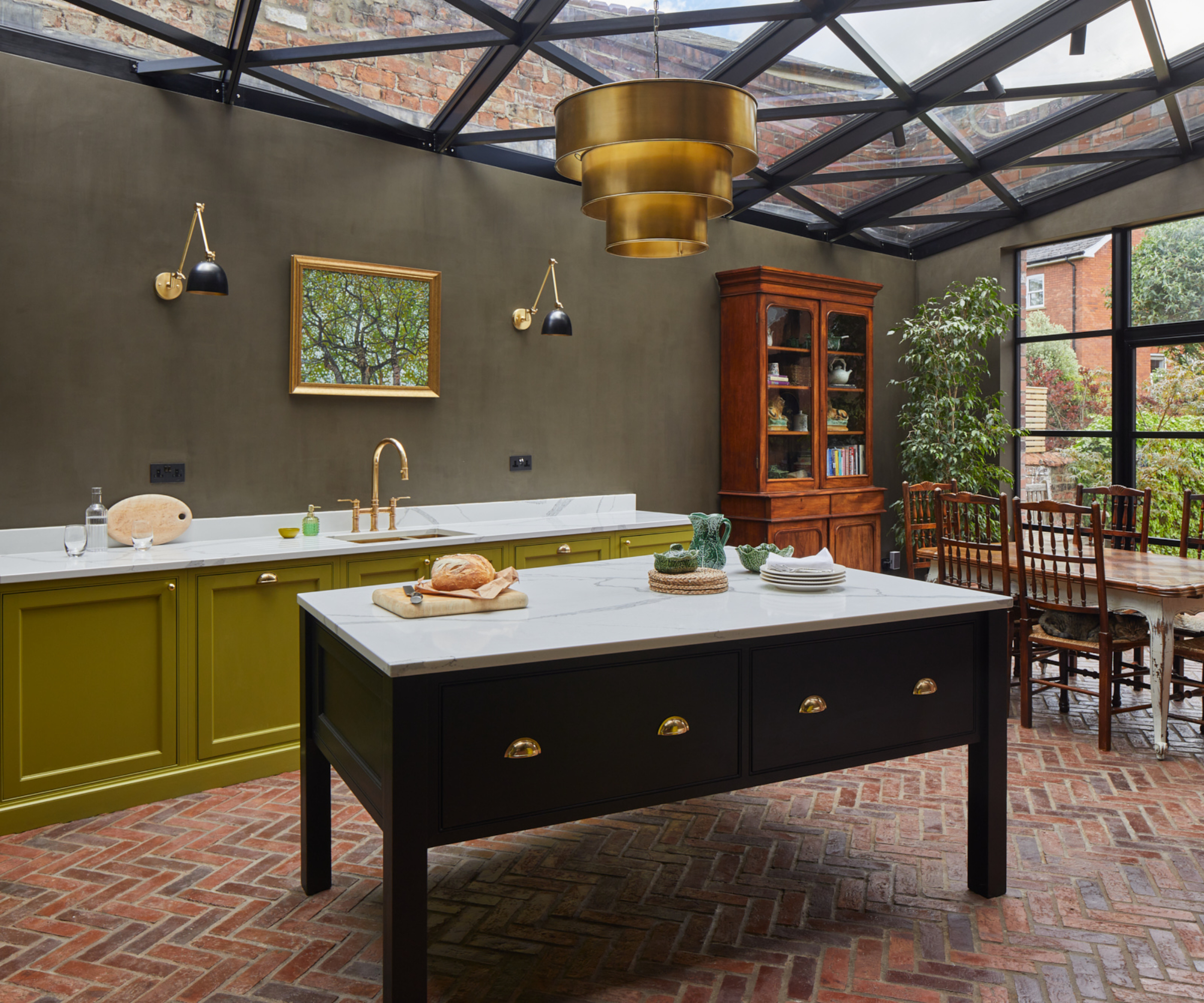 kitchen with glass ceiling with black geometric frames, large gold three tier pendant above kitchen island