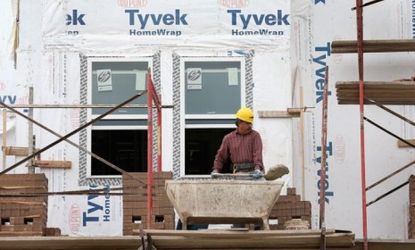 Workers apply brick facing to row houses