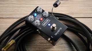 MXR Layers pedal in metallic black finish with clear controls pictured on wood floor with coiled guitar cable