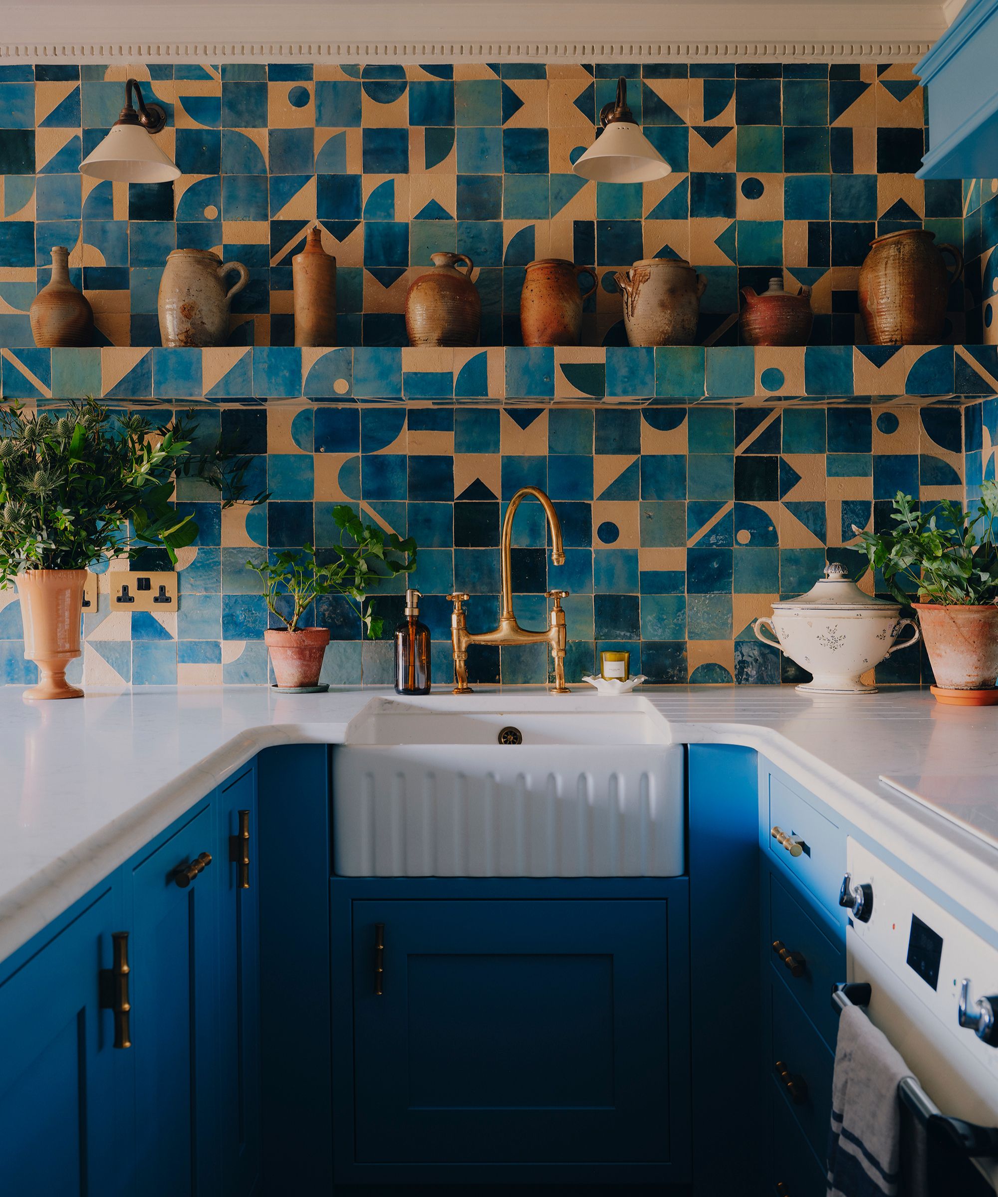 a bright blue kitchen in london with mix and match blue patterned zellige tiles