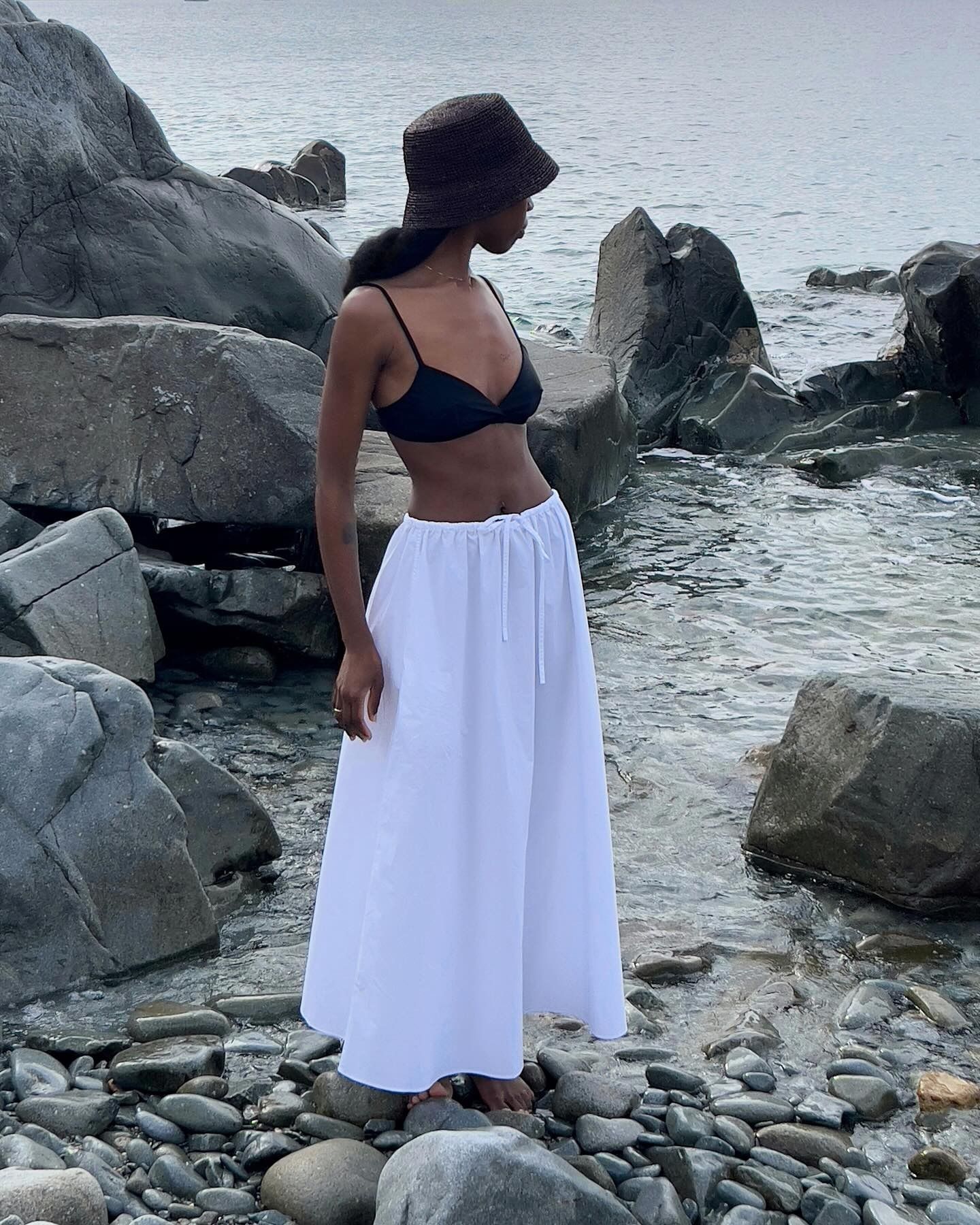 Influencer wearing white t-shirt, dotted slip skirt, and kitten heels while on European vacation.