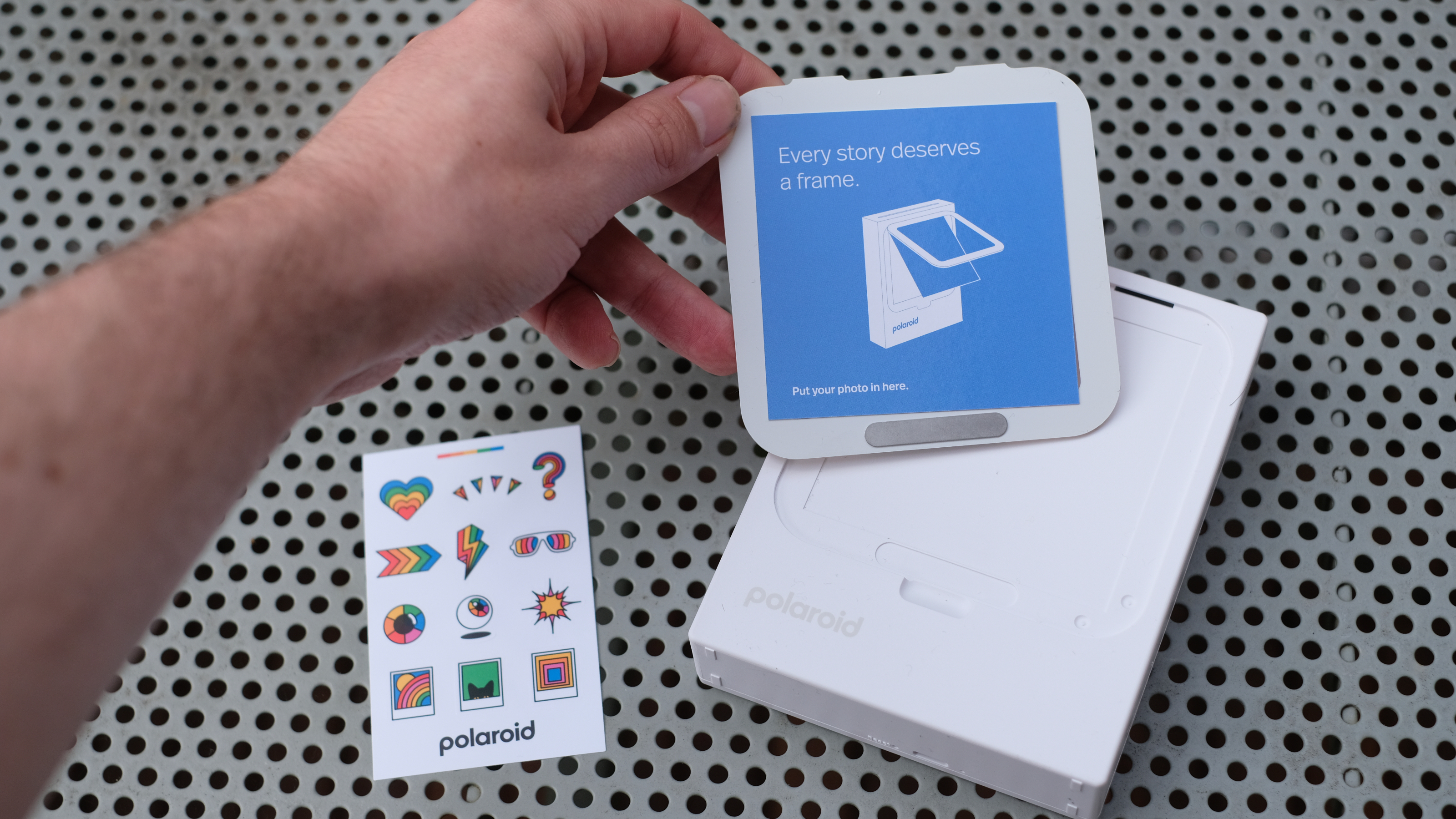 Photograph of Polaroid Hi-Print 3x3 mini instant printer with cover removed and stickers visible
