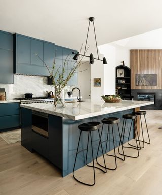 kitchen with blue cabinetry with wooden floors and marble worktops