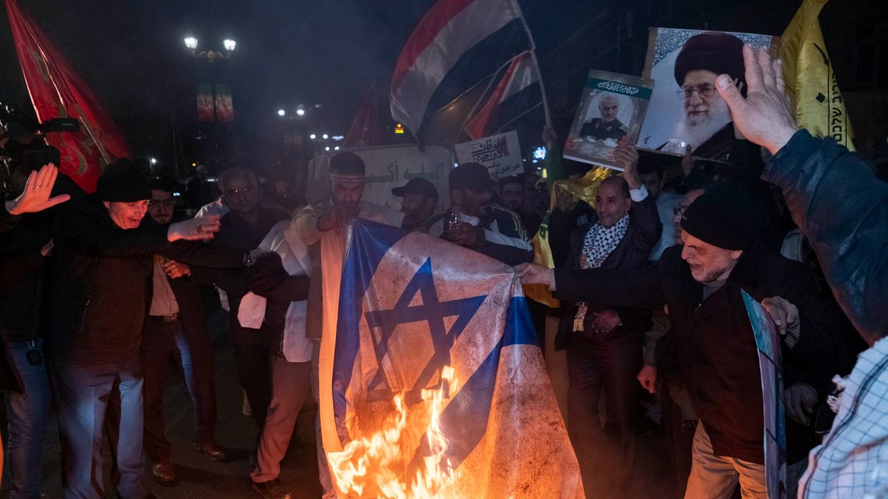 Iranian protesters are carrying a portrait of Iran&#039;s Supreme Leader Ayatollah Ali Khamenei and a Yemeni flag as they burn an Israeli flag during an anti-U.S. and anti-British protest in front of the British embassy in Tehran