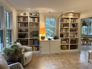 A living room with parquet flooring and built-in bookshelves