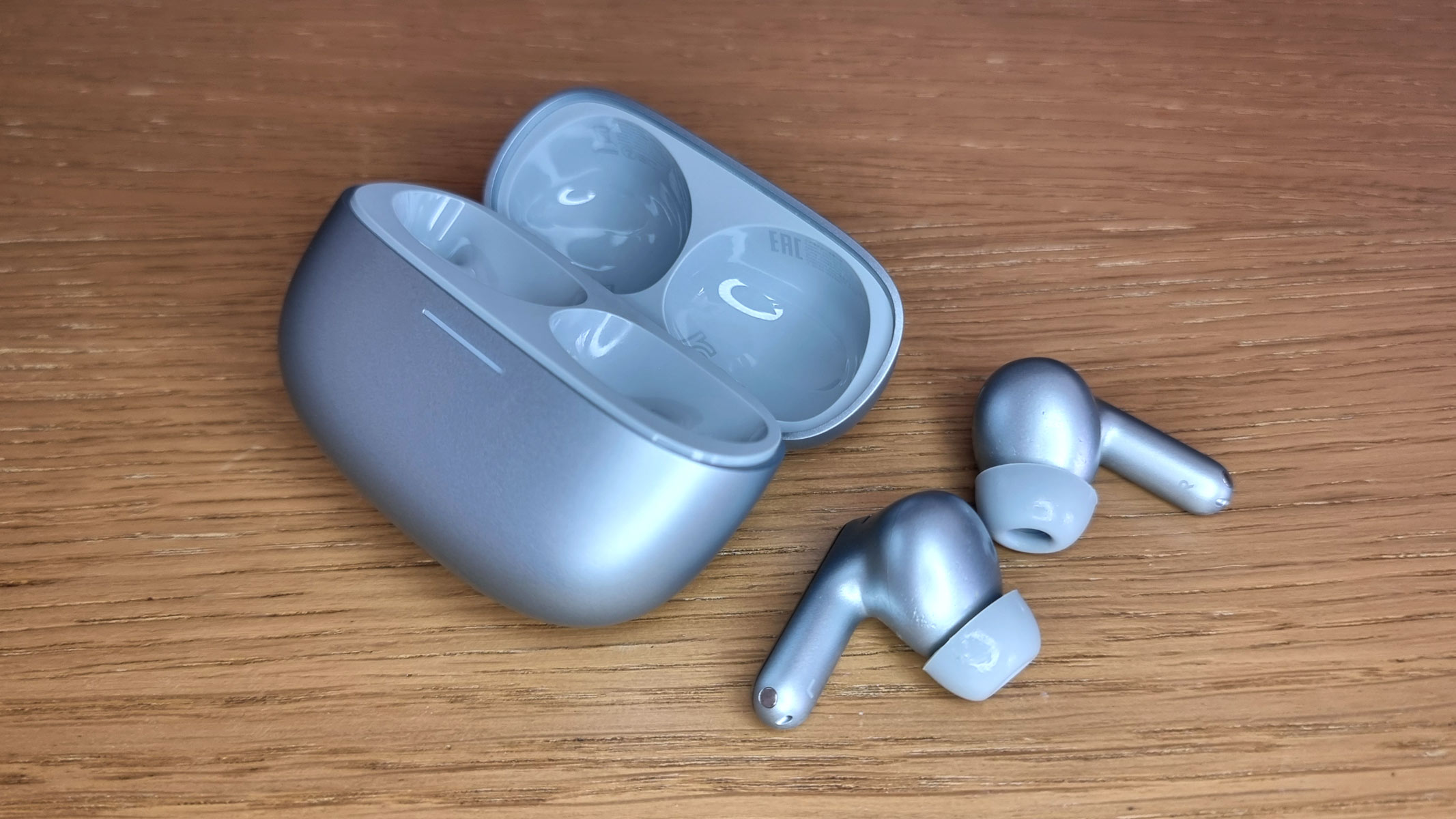 a close-up picture of the Redmi Buds 8 Pro and an open charging case