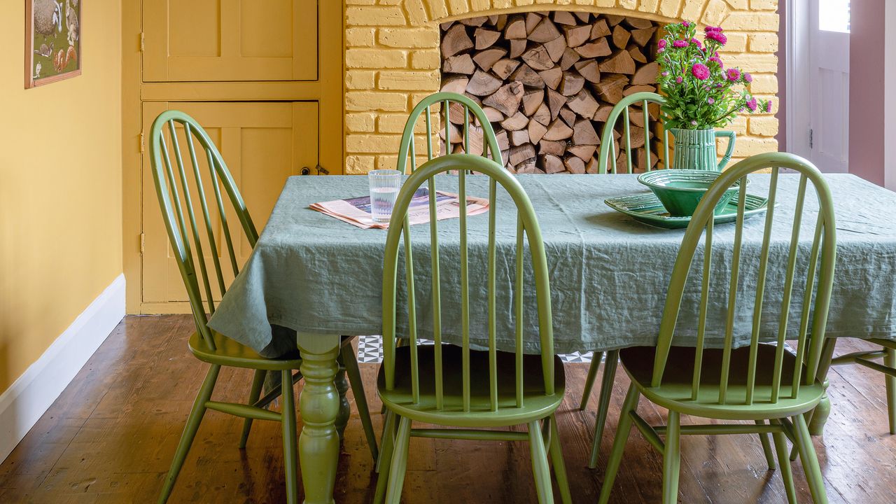 Green and yellow dining room with brick fireplace