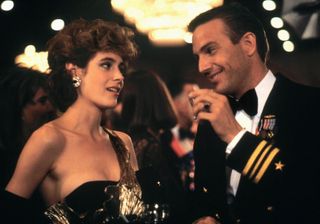 Sean Young and Kevin Costner flirt at a party