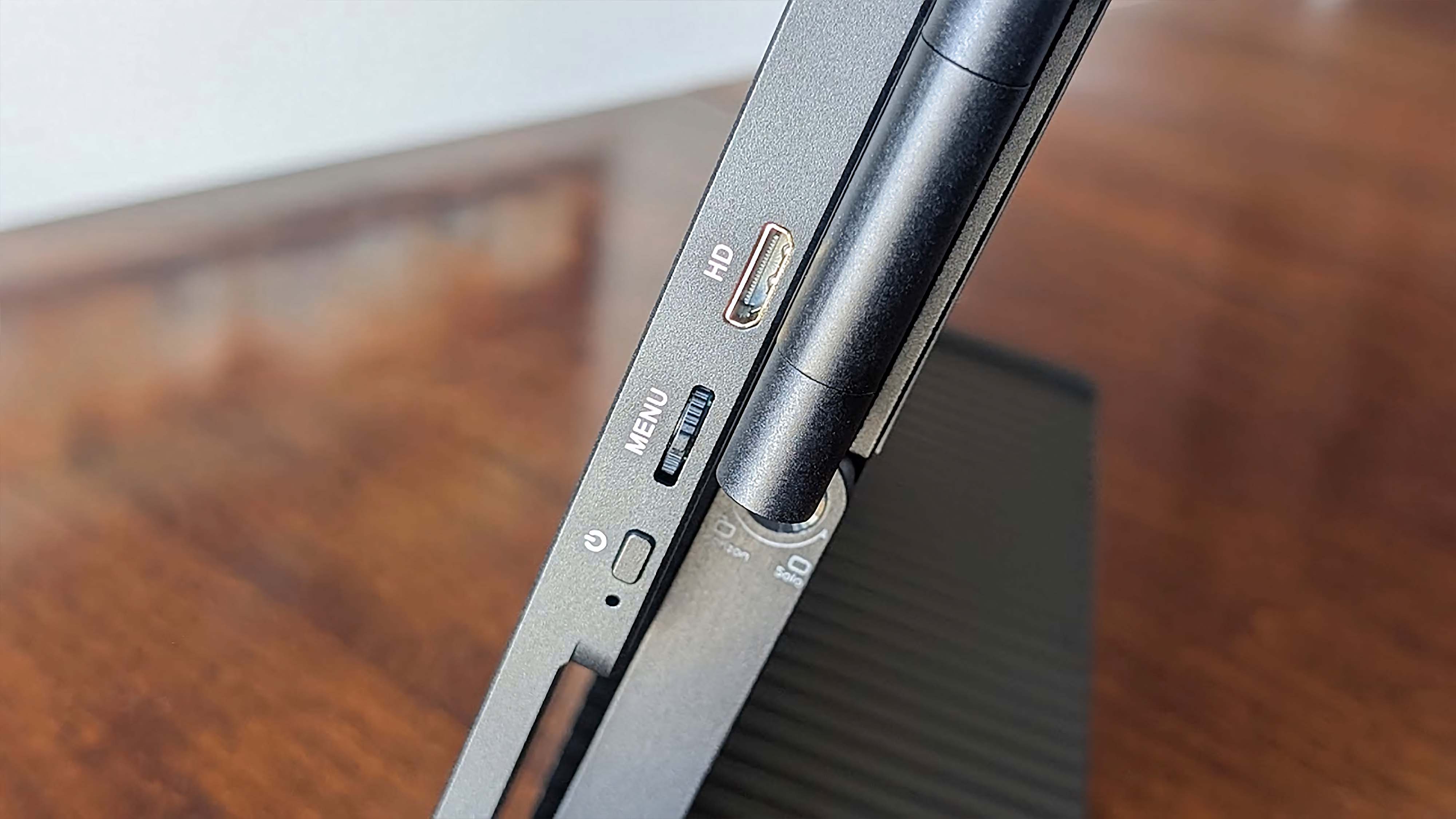 The power button, menu dial, and mini HDMI port on the side of a JSAUX FlipGo Horizon monitor. 