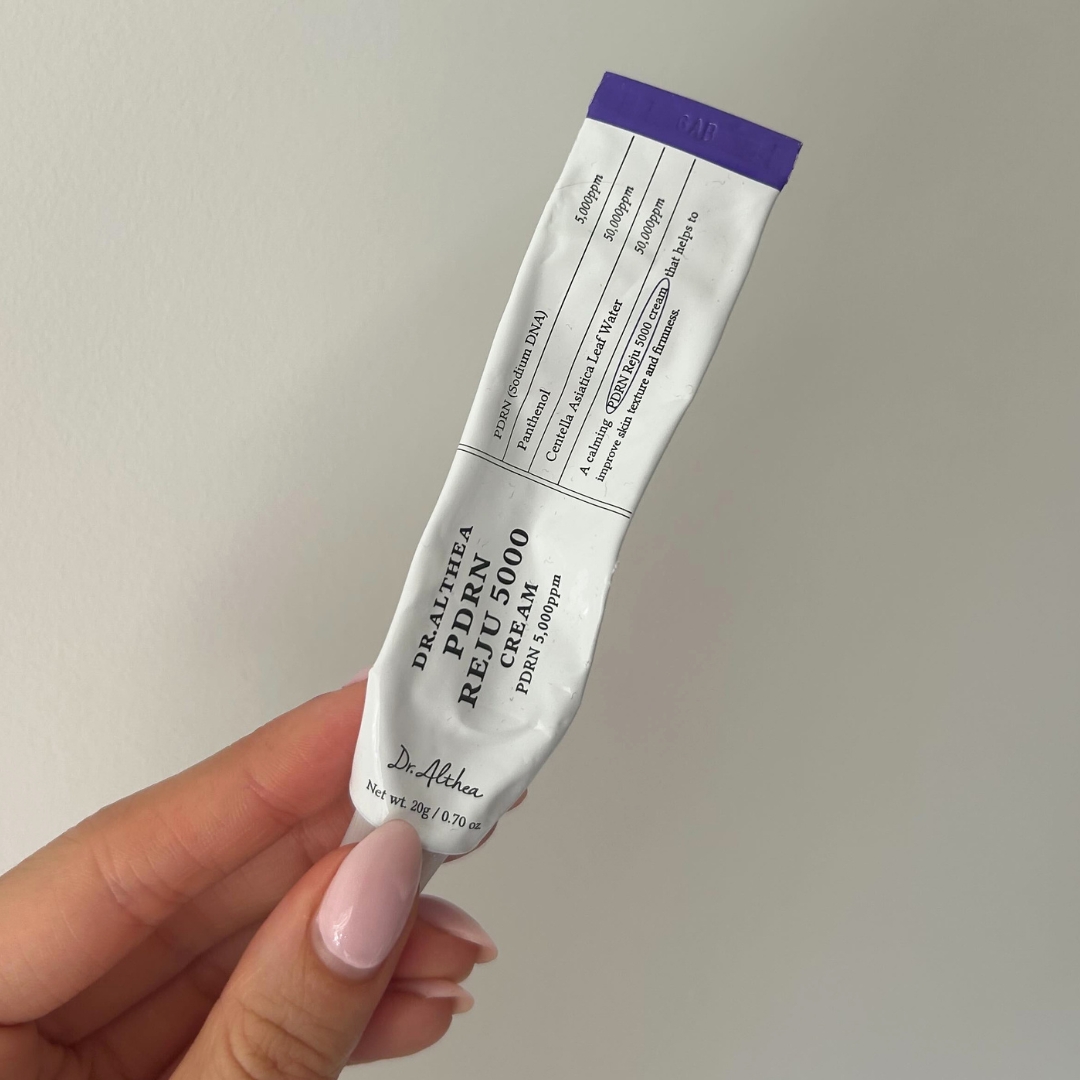Hand holding empty tube of Dr Althea PDRN Reju 5000 Cream