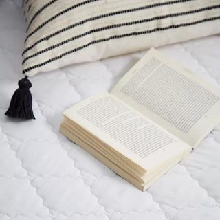White mattress protector with a book on top of it