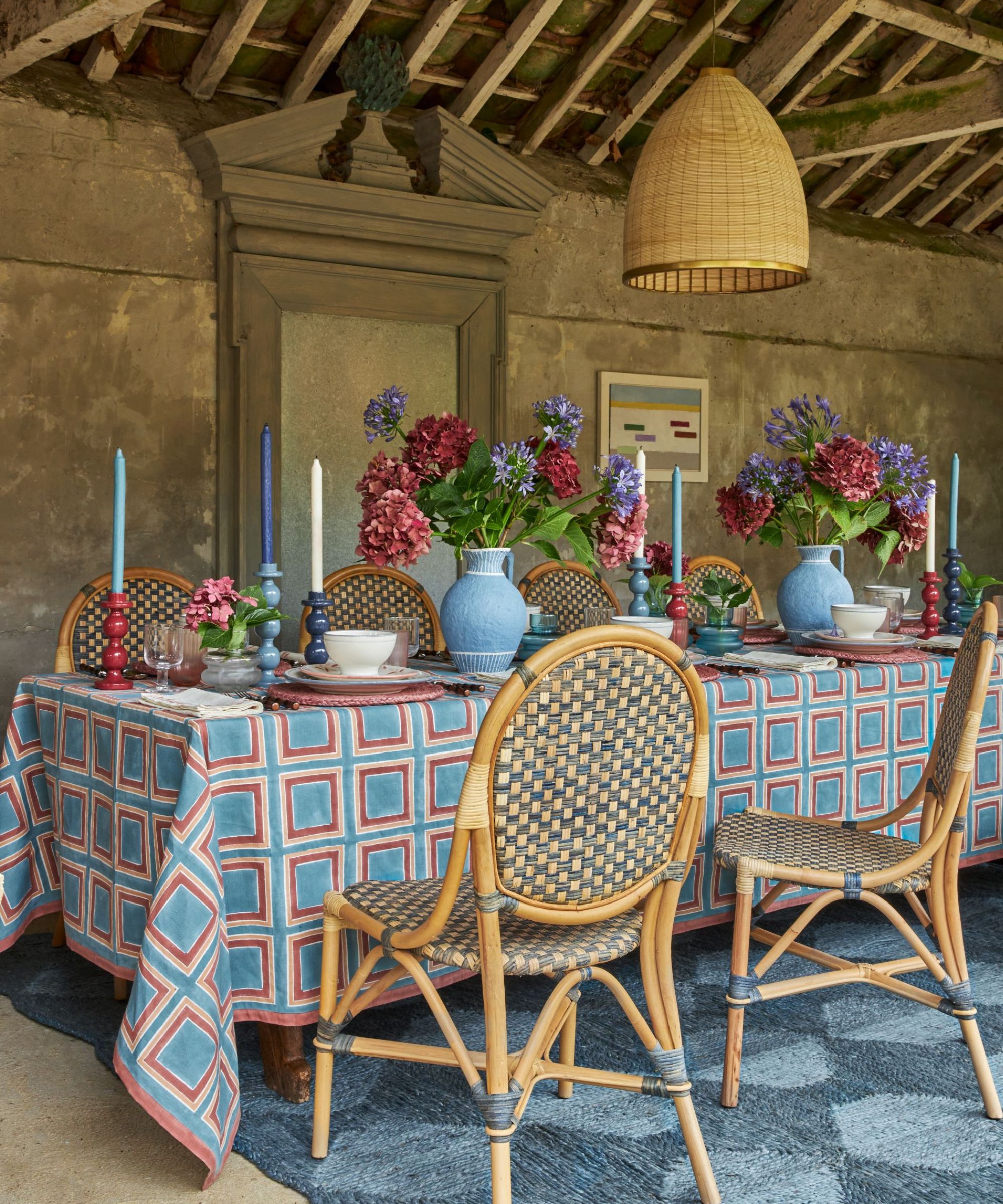 Dining table with blue and red colour scheme and rattan chairs