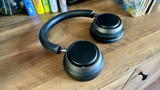 Philips Fidelio L4 noise-cancelling headphones lying flat on wooden shelf