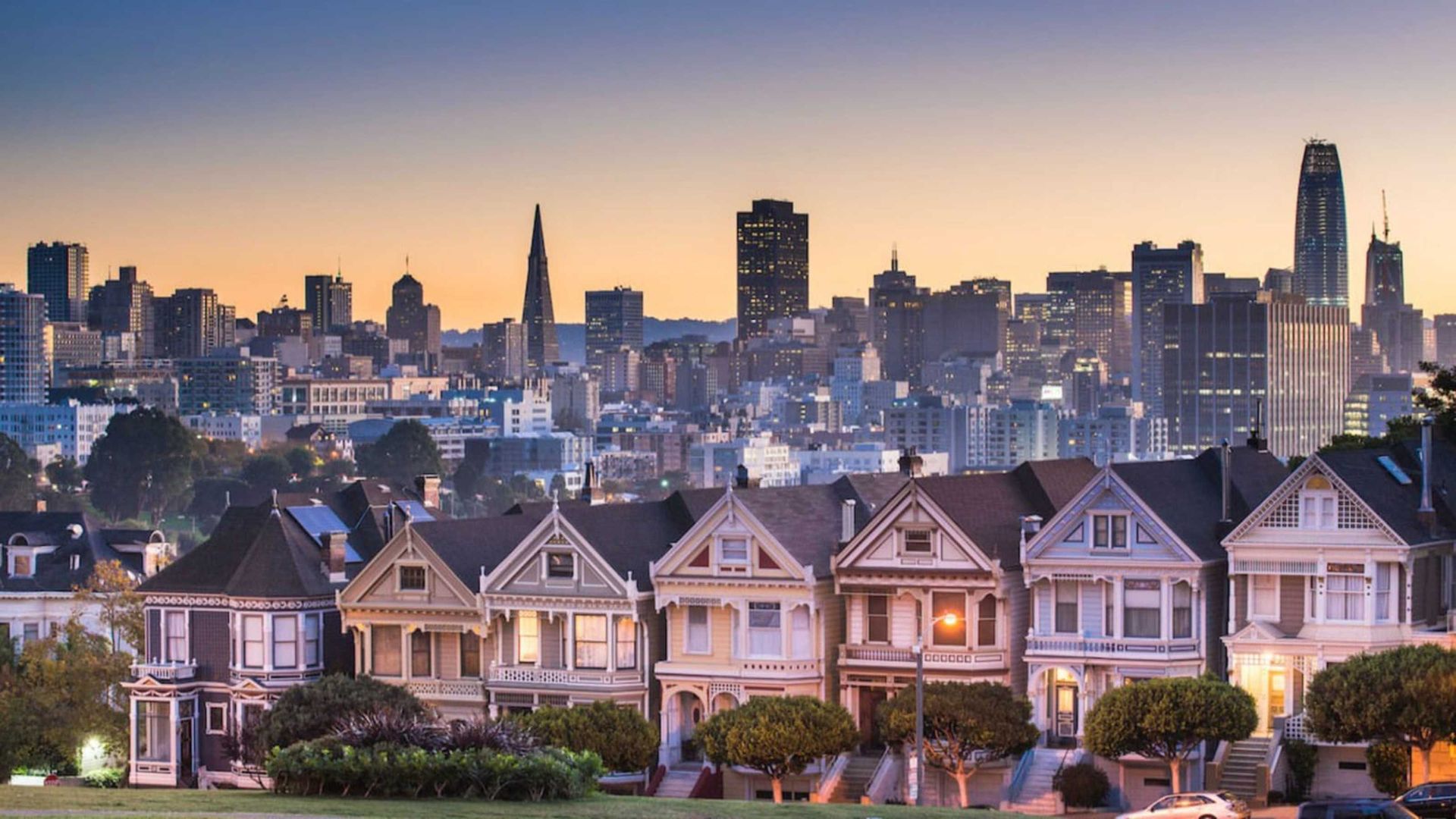Row houses in San Francisco at twilight with the city skyline in the background