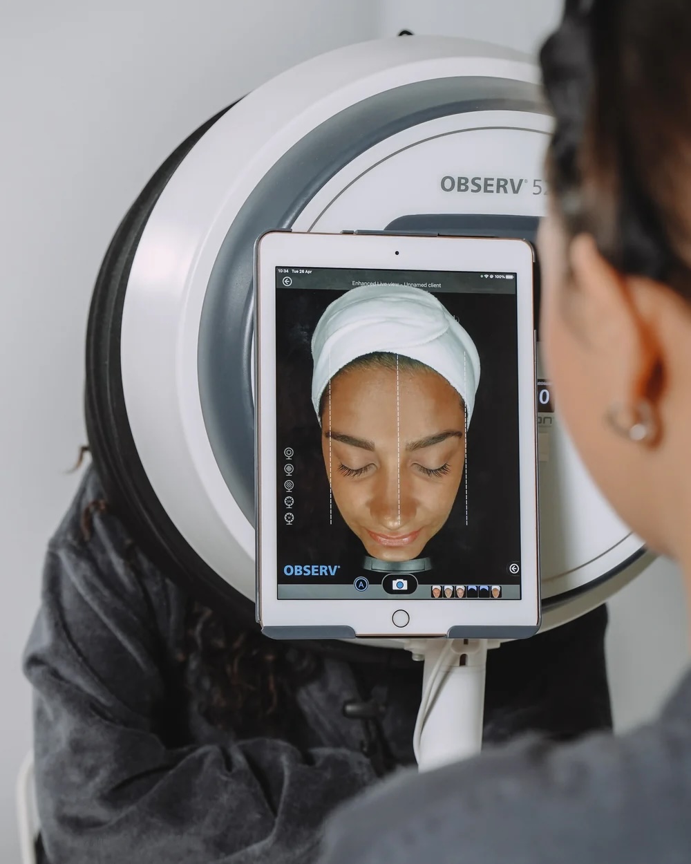 Woman having her skin analysed by a machine during a facial