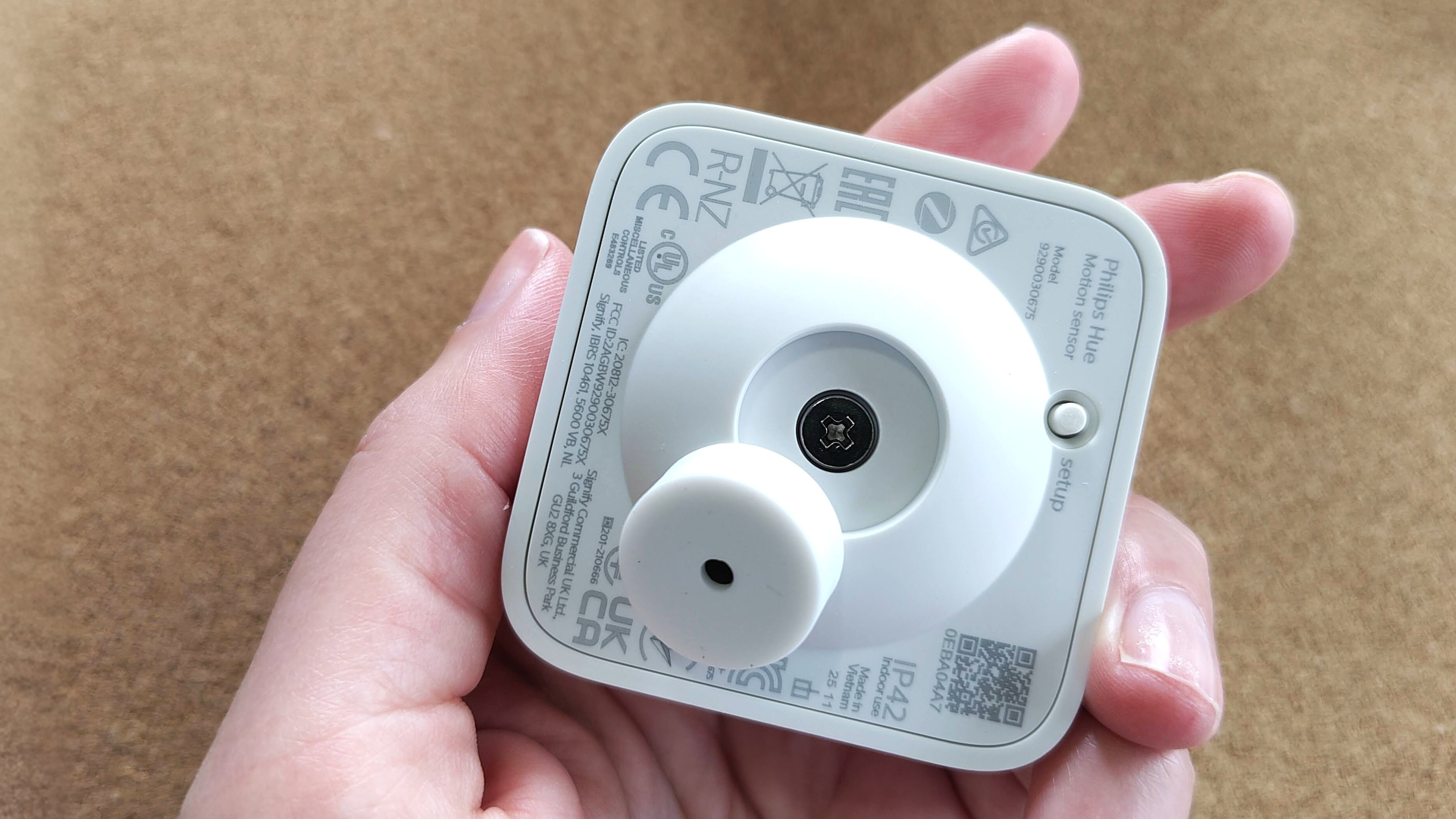 Hand holding Philips Hue Motion Sensor with magnetic mount