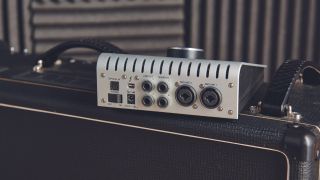 A Universal Audio interface sitting on top of a guitar amplifier
