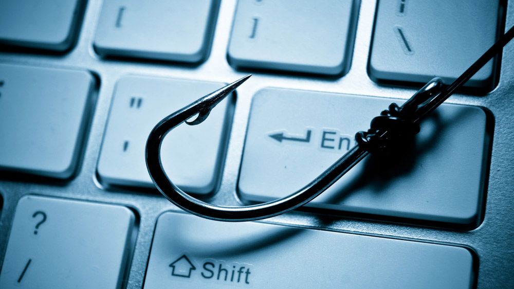 A fishing hook resting on a laptop keyboard.