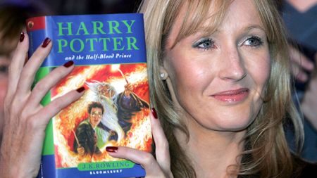 JK Rowling holding a Harry Potter book