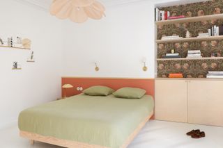 A bedding in green with a terracotta headboard