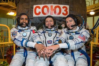 United Arab Emirates astronaut Hazzaa Ali Almansoori (left) and Expedition 61 crewmates Oleg Skripochka (center) of Russia and Jessica Meir of NASA post for a crew portrait with their Soyuz MS-15 spacecraft ahead of a Sept. 25, 2019 launch.