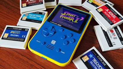 Super Pocket Capcom Edition on woodgrain desk surrounded by Evercade cartirdges.